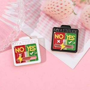 Close-up of MY ATTITUDE enamel slider pins with Yes and No options on a pink surface