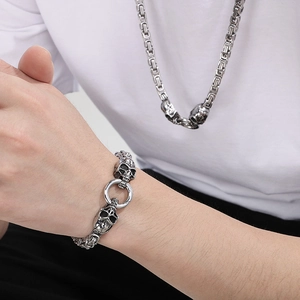 Gros plan détaillé du bracelet et du collier tête de mort punk hip-hop en acier titane