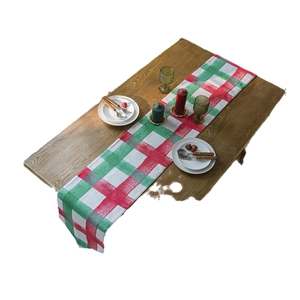 Christmas plaid table runner with red and green grid pattern on wooden table