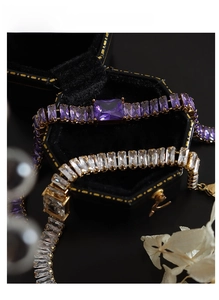 Dettaglio di bracciali tennis placcati in oro con zirconi viola e bianchi scintillanti