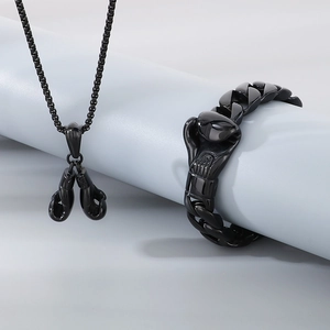 Detail of black stainless steel boxing glove pendant necklace and matching Cuban chain bracelet