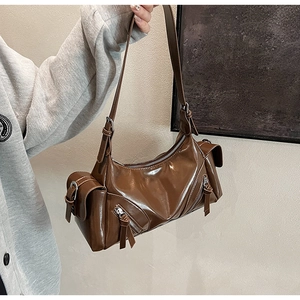 Close-up of glossy dark brown vintage crossbody bag with zippers and pockets