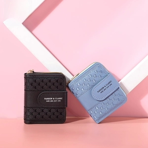 Close-up of heart-embossed faux leather wallet with zipper and snap button closure