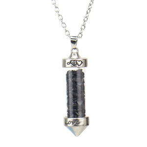 Detail view of heart and Love engravings on silver cap of a stone-filled glass vial pendant