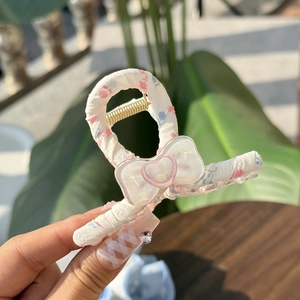 Floral fabric hair claw clip with heart bow detail and metal spring close-up