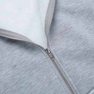 Détail du tissu en maille grise avec doublure en laine d'agneau blanche et zip en métal