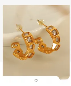 Detailed macro view of 18K gold plated titanium C-shape earrings with cubic zirconia