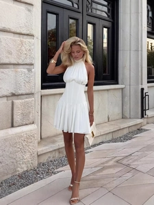 Mini robe blanche à licou avec jupe plissée et taille cintrée pour un look chic
