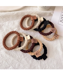 Detailed view of elastic hair ties in earth tones with bear handmade leather labels
