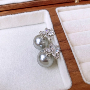 Detail of luxury butterfly pearl earrings with zircons in a wooden jewelry box