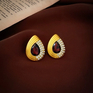 Vintage gold teardrop earrings with deep red gemstones and white crystals on silk