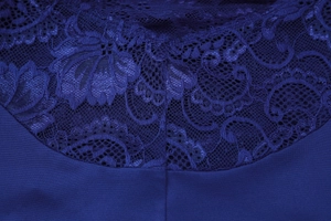 Détail macro d'une robe bleu foncé avec dentelle délicate et texture de tissu premium