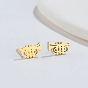 Macro view of gold trumpet-shaped stud earrings with intricate musical instrument details