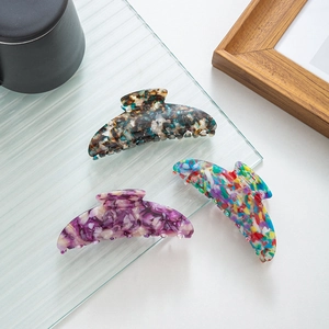 Detailed view of tortoiseshell, purple marble, and floral acetate crescent hair claws