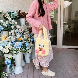 Detail of cream plush bear tote bag with 3D pink pompoms and cartoon embroidery