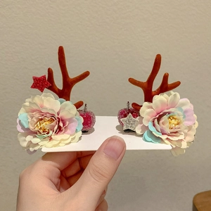Detailed view of plush reindeer antler hair clips with gradient flowers and glitter stars