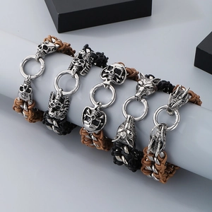 Detail of gothic leather bracelets featuring silver skull, wolf, and dragon steel charms
