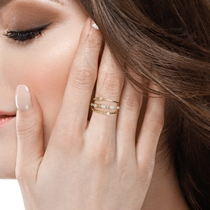 Luxurious gold triple-band ring with pavé diamonds worn by model for elegant banquets