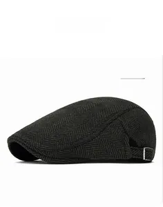 Detailed view of the dark green herringbone newsboy cap featuring a metal side buckle