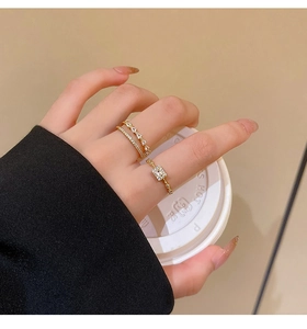 Close-up of gold plated layered rings set with white zircon stones on model's hand