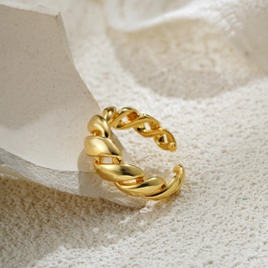 Macro shot of 18K gold twist rope ring with minimalist open design on stone base