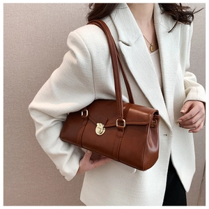 Nahaufnahme einer braunen Vintage-Unterachseltasche aus Leder mit eleganter goldener Schnalle