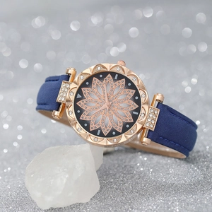 Detailed macro view of a rose gold women's watch with crystal-encrusted floral dial