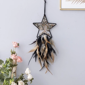 Detailed shot of star-shaped dream catcher with tree of life stones and dark feathers