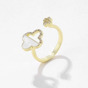 Golden open ring featuring white mother of pearl and crystal clover designs on a white base