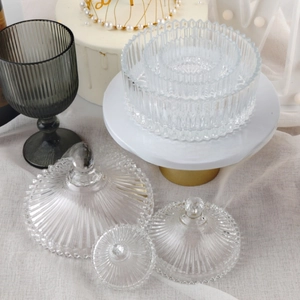 Close-up of ribbed glass storage jars with beaded lids and matching smoke gray goblet