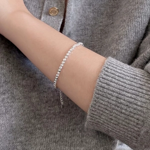 Close-up of a minimalist 925 sterling silver beaded bracelet on a woman's wrist