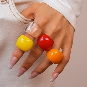 Close-up of vibrant square resin rings in transparent, yellow, red and orange colors