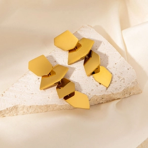 Detailed view of gold irregular geometric petal earrings on white stone tray and silk