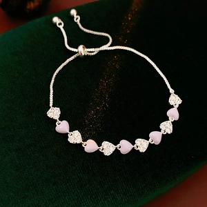 Macro shot of silver heart bracelet with purple stones and zircon on green velvet