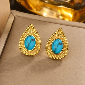 Macro view of vintage golden turquoise earrings with pearl details in a luxury box