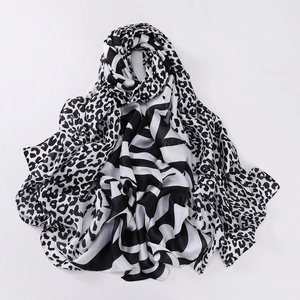Close-up of black and white leopard print silk scarf with abstract stripe patterns