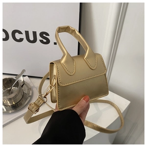 Detailansicht der kleinen goldenen Umhängetasche mit Metallic-Finish und Riemen