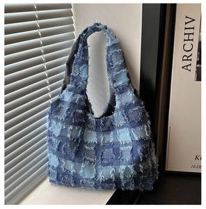 Close-up of patchwork denim tote bag with frayed edges and textured blue fabric