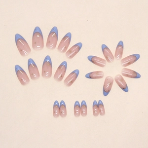 French almond press-on nails with blue tips and gold star patterns on nude base