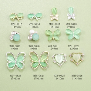 Detailed grid showing mint green cat-eye butterfly and bow nail art charms with sizes