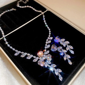 Macro view of crystal flower and wheat tassel jewelry set in a black velvet box