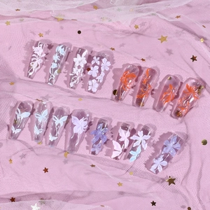 3D floral and goldfish embossed clear press-on nails set on pink starry mesh background