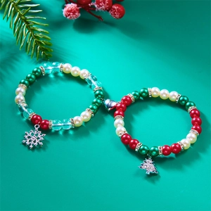 Detail of Christmas magnetic bracelet with snowflake tree charms and red green pearls