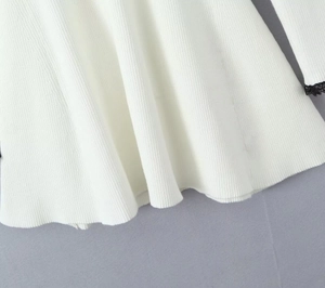 Primer plano de tela de punto acanalado blanco con ribete de encaje negro fino