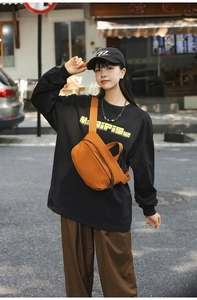 Orange nylon crossbody bag for casual daily wear shown in a street style outdoor view
