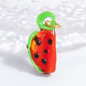 Macro shot of glass watermelon pendant with vibrant red core and golden metal ring