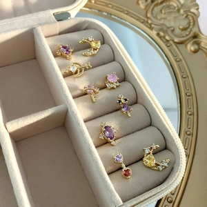 Detail of colorful zircon stud earrings with moon, star, and heart shapes in a velvet box
