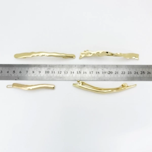 Irregular golden alloy spring hair clips for women shown with measurement scale