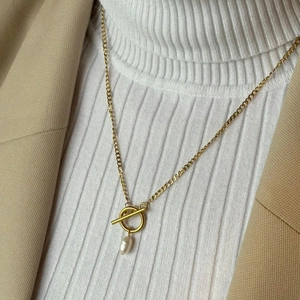 Detail of 18K gold stainless steel necklace with toggle clasp and pearl charm