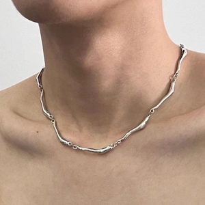 Minimalist silver wavy chain necklace with irregular fluid design on a model